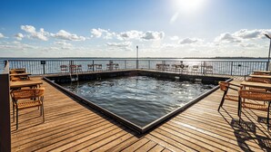 A wooden deck with a pool, chairs, and tables. - Grandes Lagos Resorts e Parque Aquático (Santa Clara d'Oeste)