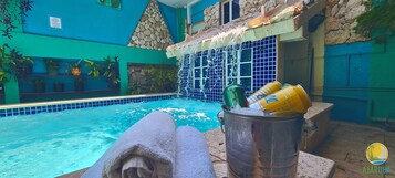 Una piscina al aire libre, sillones reclinables de piscina