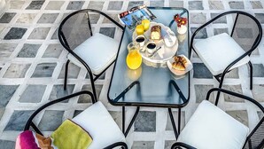 A patio with a tiled floor and a table set for breakfast. - Casa Veneziana Chania, Casa Veneziana (Chania)