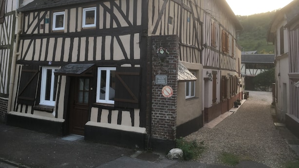 Un edificio tradicional con entramado de madera, un pequeño porche y una puerta.