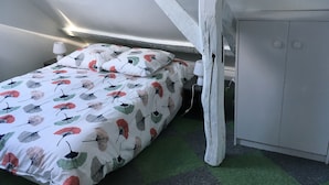 Una habitación pequeña y funcional con cama, mesita de noche y armario.