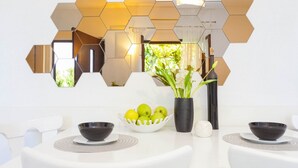 A modern dining area with a white table, hexagonal mirrors, and a vase with flowers. - Holiday home Mendy with Jacuzzi in the garden in a quiet location above Tučepi (Tučepi)