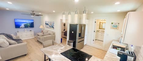 A modern kitchen with a central island, built-in appliances, and pendant lighting.
