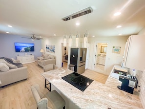 A modern kitchen with a central island, built-in appliances, and pendant lighting.