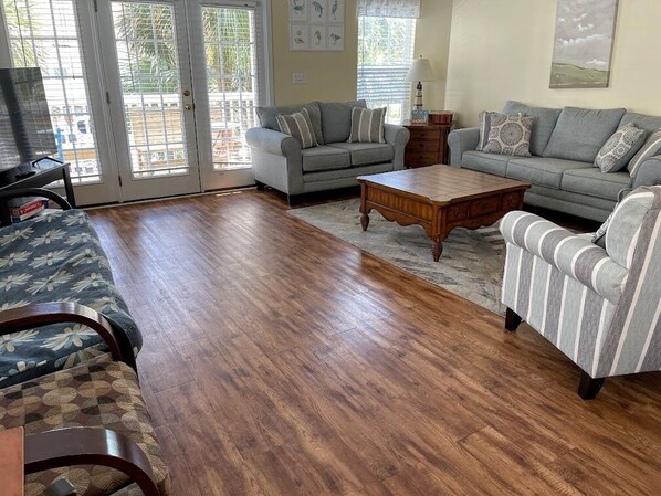 A living room with a grey sofa, striped armchair, and a wooden coffee table.
