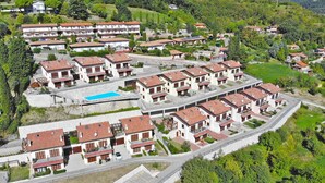 Ein Wohngebiet mit mehreren zweistöckigen Häusern, einem Schwimmbad und einer gewundenen Straße.