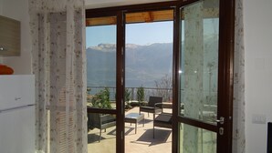 Ein Balkon mit Blick auf die Berge, einem Tisch und Stühlen.