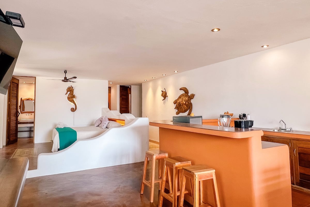 Una cocina moderna con barra, taburetes de madera y decoración mural.