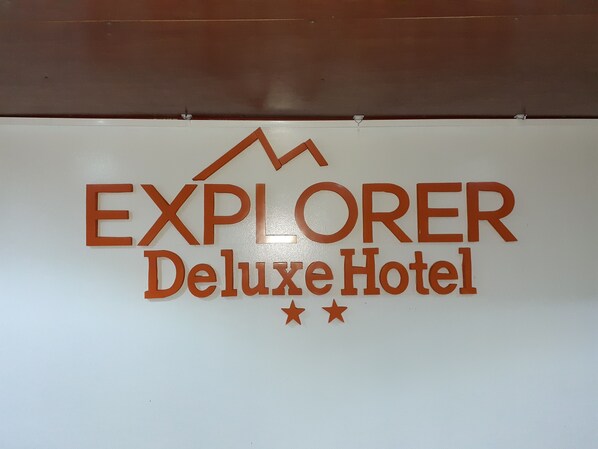 Señal del Hotel Explorer Deluxe con un gráfico de montaña y dos estrellas.