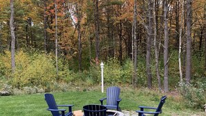 A circular stone patio with four Adirondack chairs and a fire pit. - Goose Rocks Retreat - relax, refresh, recharge  (Kennebunkport)