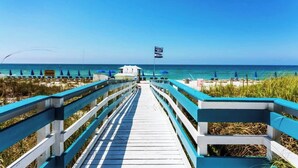 A wooden boardwalk leading to a beach area with umbrellas and lounge chairs. - “Barefoot Bliss” - Two GulfFront Masters w/balcony (Panama City Beach)
