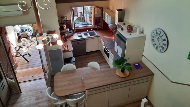 A compact kitchen with a dining area, a clock on the wall, and a view of the outside. - 70 m² modern house, 650 m from the beach, rated 3 stars. 2027 RATES OK (Fleury)