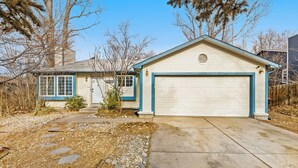 Une maison de plain-pied avec un garage, un petit abri attenant et une allée gravillonnée.