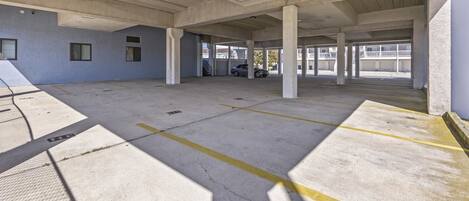 Un garaje de estacionamiento vacío con pilares de concreto y espacios delimitados.