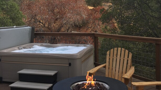 A hot tub on a deck with a fire pit and wooden chairs. - Little Bear Cottage Private,Luxury Getaway!SPA! FIRE PIT! 3 MLS FROM SNP (Three Rivers)