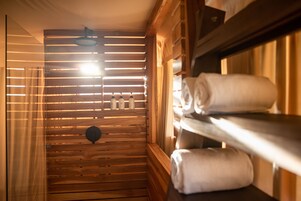 A wooden sauna room with benches and towels.