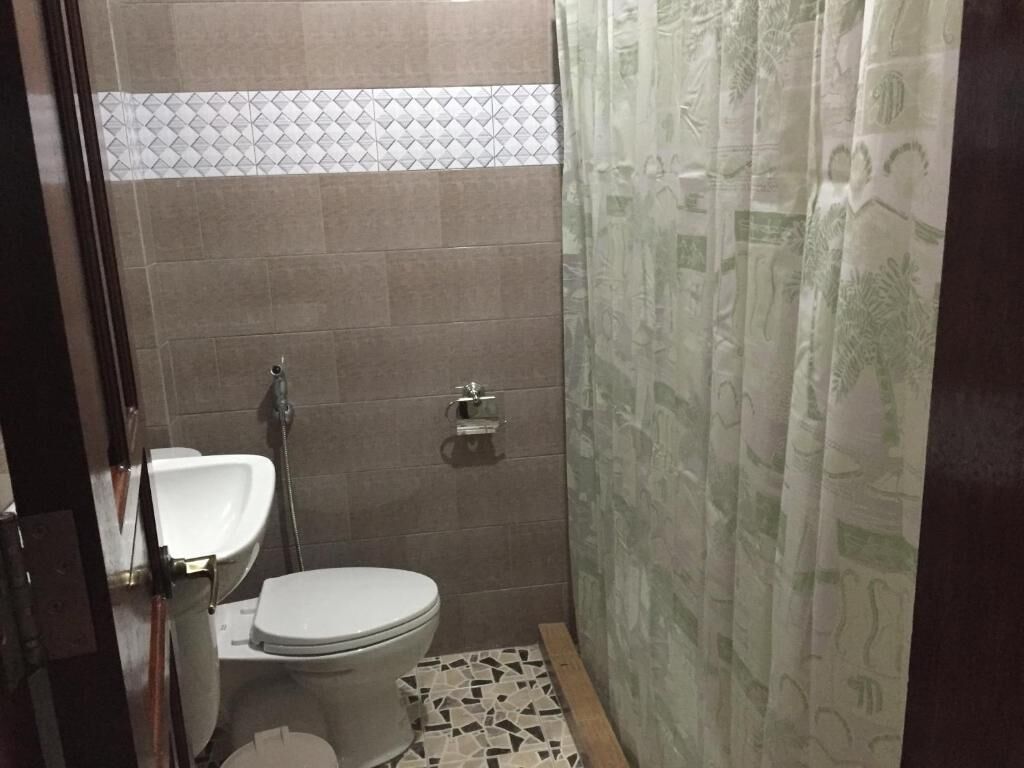 Un baño pequeño con inodoro, lavamanos y ducha.
