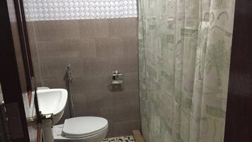 Un baño pequeño con inodoro, lavamanos y ducha.