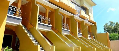 Un edificio de varios pisos con escaleras exteriores y balcones.