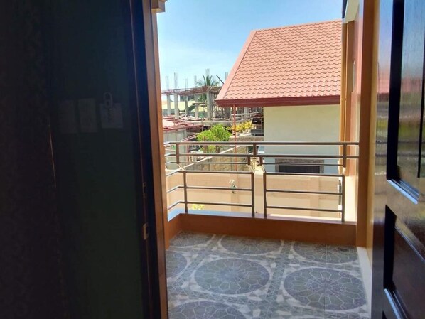 A view from a balcony with a tiled floor and a railing. - Golden Pension House (Puerto Princesa)