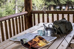 A wooden bench with a map, a kettle, a mug, and a backpack.