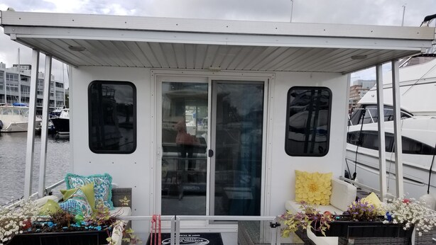 A covered deck area with wicker furniture and potted plants. - Charlestown Houseboat Walk to attractions Be rocked to sleep (Boston)
