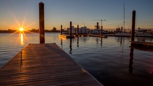 A wooden dock extending into calm water with a sunset in the background. - Charlestown Houseboat Walk to attractions Be rocked to sleep (Boston)