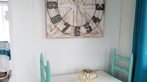 A white table with teal chairs, a decorative metal clock, and a small pumpkin ornament. - Charlestown Houseboat Walk to attractions Be rocked to sleep (Boston)