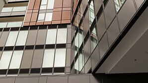 A modern building facade with a prominent "RAMADA" sign at the bottom. - Ramada Suites By Wyndham Victoria Street West (Auckland)