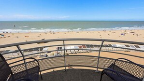 A beach view from a covered area with seating. - Residentie Zeezicht, Ref 104 (Oostende)