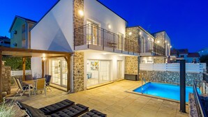A modern two-story house with a stone facade, a balcony with a metal railing, and a swimming pool. - Beautiful home in Kornic (Kornic)