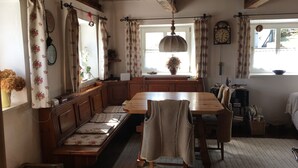 A cozy kitchen with wooden furniture, a bench, and a dining table.