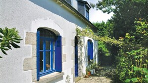 A building with white walls and blue shutters, a gravel path, and potted plants. - 2 bedroom pet friendly home in Plourivo (Plourivo)