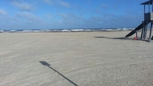 Una spiaggia con una torretta di salvataggio e un cielo sereno.