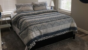 A bedroom with a bed, two windows with blinds, a lamp, and a wall decoration. - 2 bedroom + 1 bath apartment with amazing views! (Missoula)