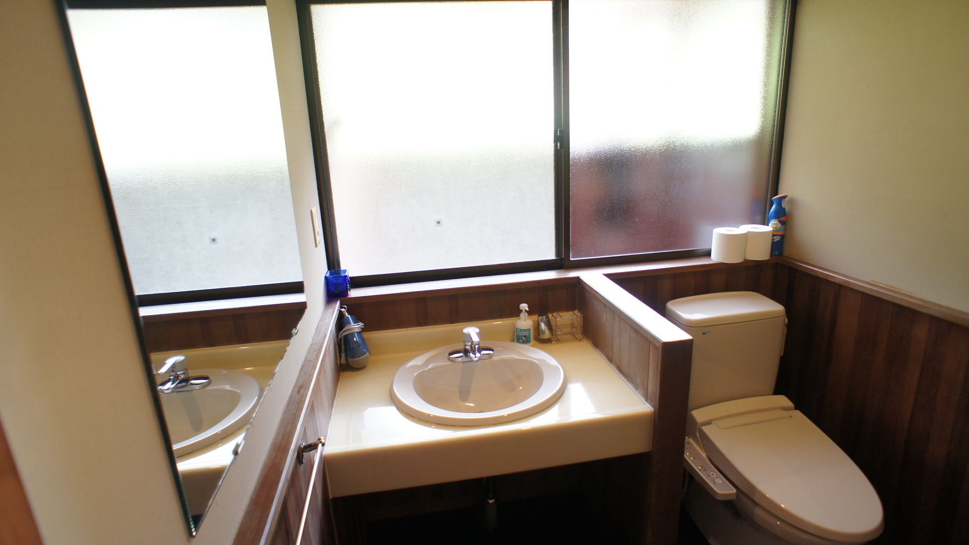 A bathroom with two sinks, a toilet, and a window.