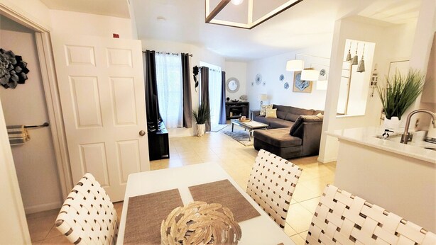 A modern living room with a sofa, coffee table, and decorative items. - Amazing main floor resort style condo at Avalon (Clearwater)