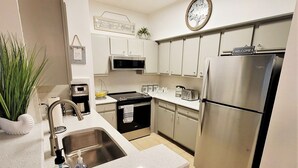 A modern kitchen with stainless steel appliances, a sink, and a countertop. - Amazing main floor resort style condo at Avalon (Clearwater)