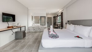 A modern hotel room with a large bed, a TV mounted on the wall, a small kitchenette, and a bathroom visible through an open door. - Monotel Aonang (Krabi)