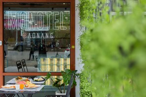 A restaurant with a glass window displaying the name "MOHOTEL @ AONANG". - Monotel Aonang (Krabi)