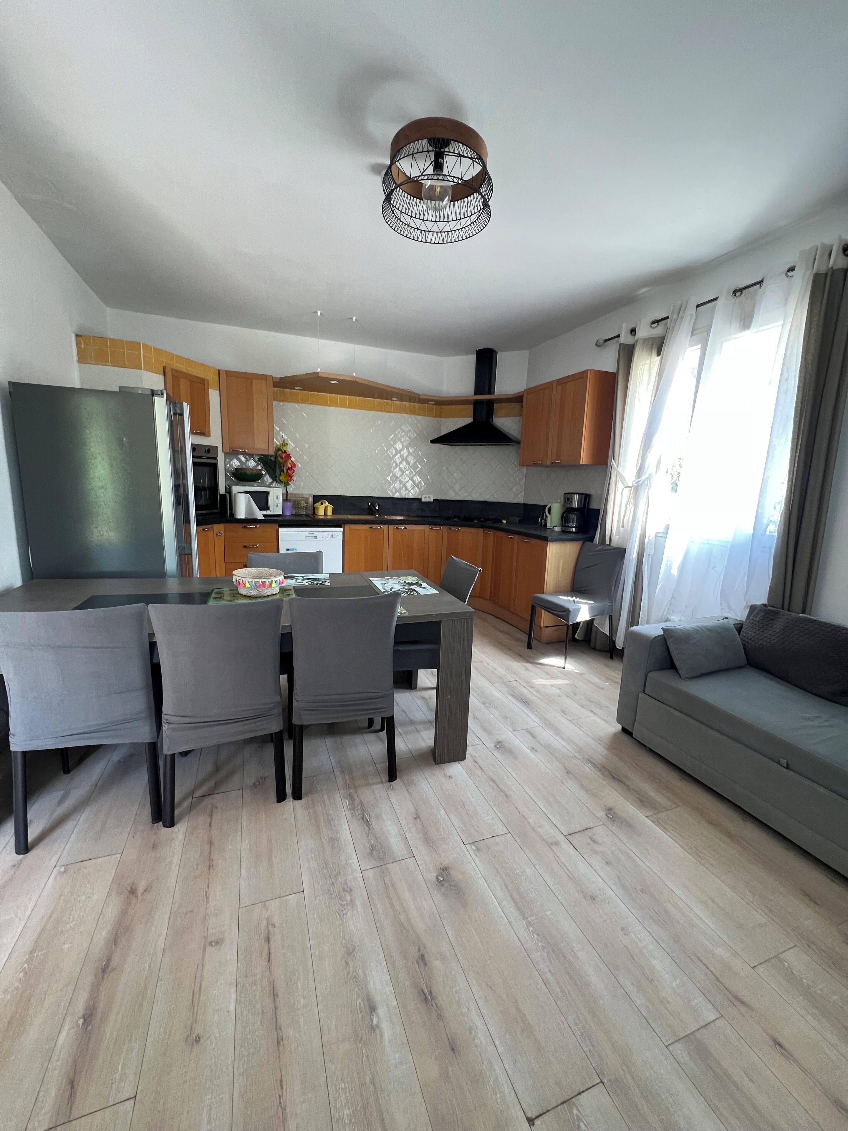 Une cuisine moderne avec des meubles en bois, un four encastré et un four à micro-ondes.