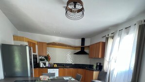 Une cuisine moderne avec des meubles en bois, un four encastré et un four à micro-ondes.