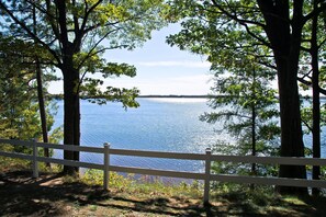 A lake view with a white fence in the foreground.