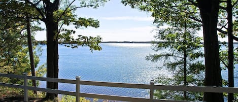 Vista de un lago con una cerca blanca al frente.