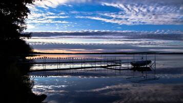 A calm lake with a dock and a row of flags.