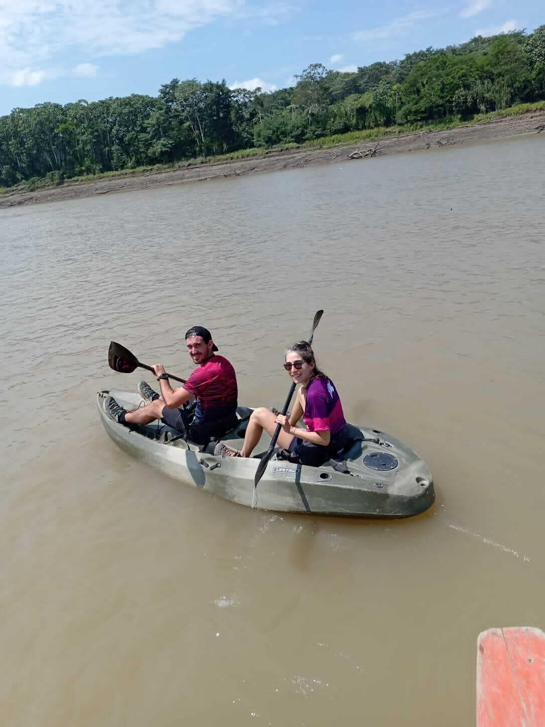 Two people in a canoe on a calm river.