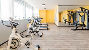 A gym with exercise bikes, treadmills, and weight machines. - Atour S Hotel (Guangzhou)