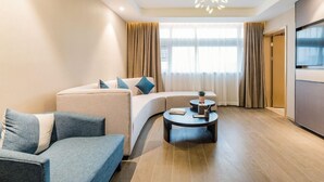 A modern living room with a sofa, a coffee table, and a TV. - Atour S Hotel (Guangzhou)
