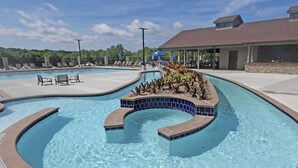 Ein Pool mit geschwungenem Design, umgeben von Liegestühlen und einem überdachten Bereich mit Blick auf Bäume.