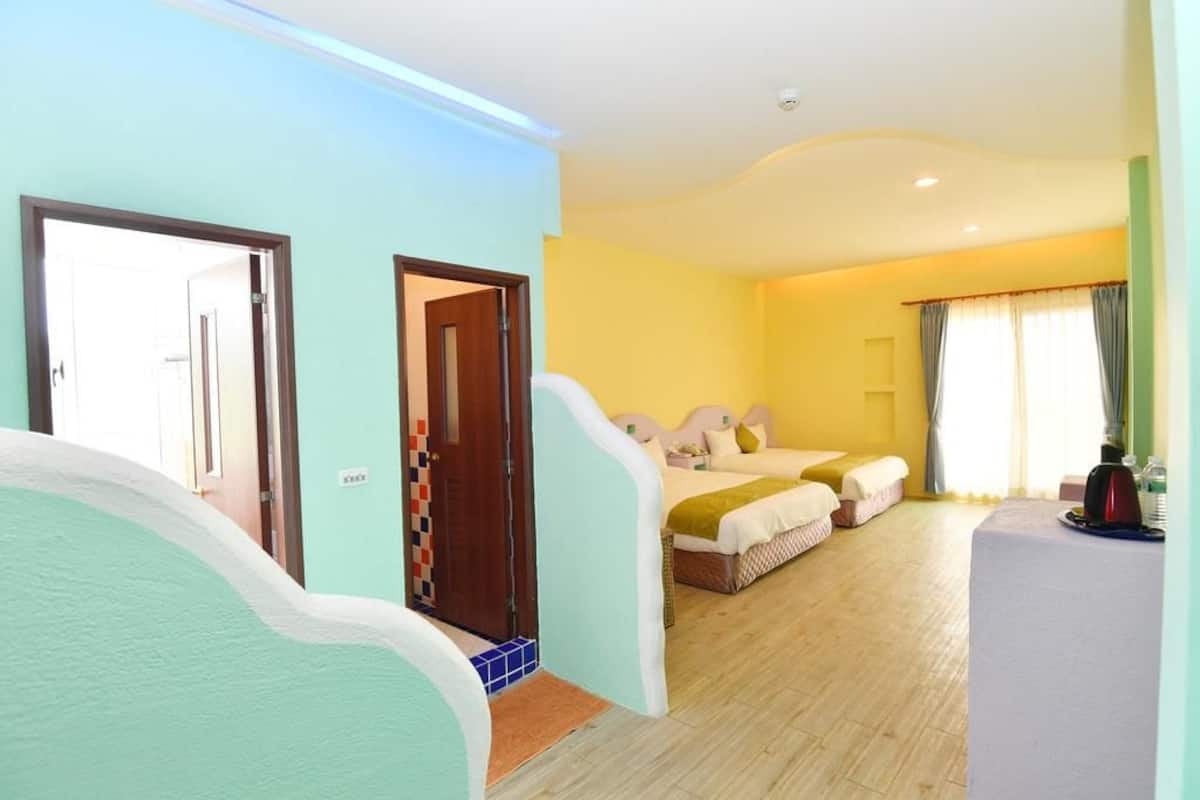 Habitació d'hotel amb un llit, taules de nit i una finestra amb cortines.